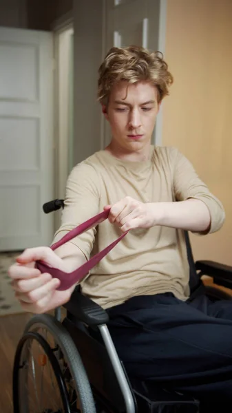 A disabled man is making hand exercises with sporty elastic — Stock Photo, Image