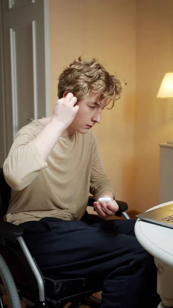 A disabled young man is watching a movie attentively — Stock Photo, Image