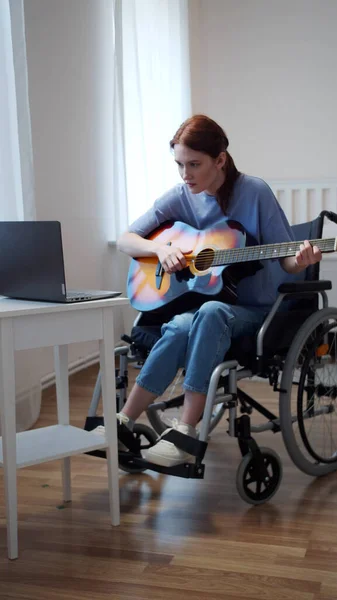Una mujer discapacitada está aprendiendo a tocar la guitarra — Foto de Stock
