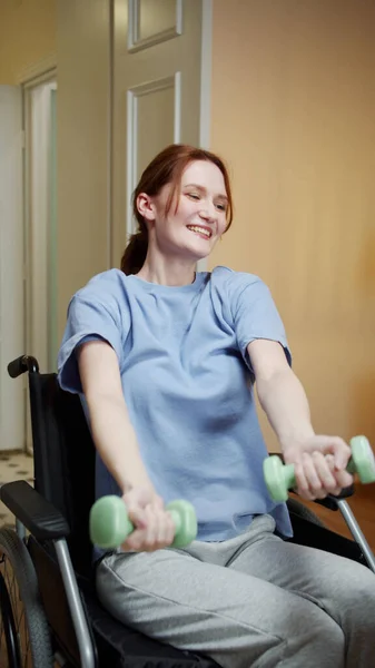 A disabled woman is making an exercise with dumbbells on the Internet — Stock Photo, Image