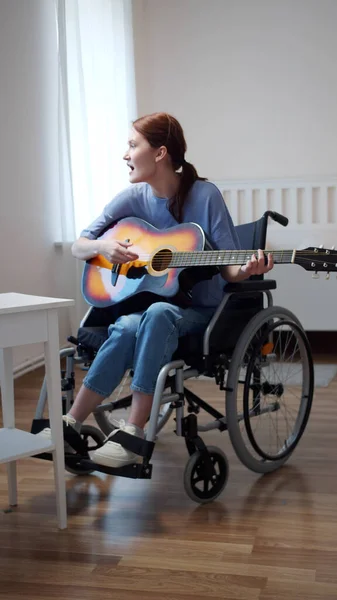 A disabled lady is playing the guitar and singing songs — Stock Photo, Image