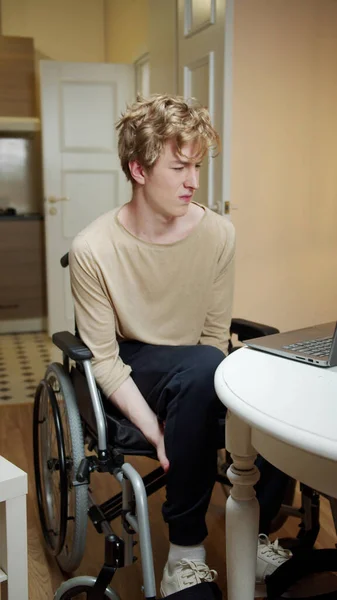 Молодой инвалид массирует ноги. — стоковое фото