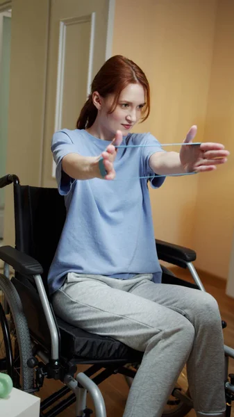 Une femme handicapée fait des exercices manuels avec élastique sportive — Photo