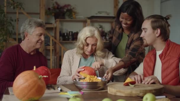 Familie helpen oude dame om een pompoen te maken voor halloween — Stockvideo