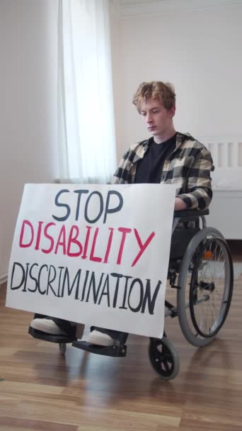 Seorang penyandang cacat menunjukkan poster dan melihat ke kamera — Stok Video