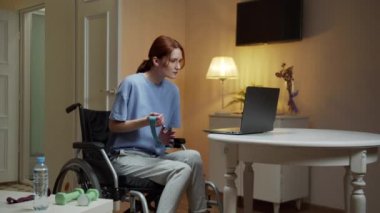 Engelli bir kadın özel ekipmanlarla el egzersizi yapıyor.