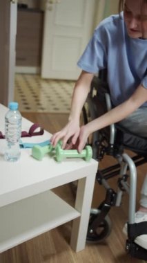 Engelli bir kadın özel ekipmanlarla el egzersizi yapıyor.