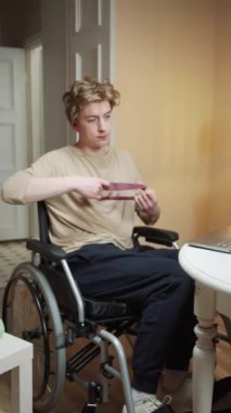 Engelli bir adam spor lastiğiyle el egzersizi yapıyor.