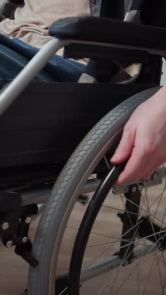 Людина з обмеженими можливостями їде на інвалідному візку через кімнату — стокове відео