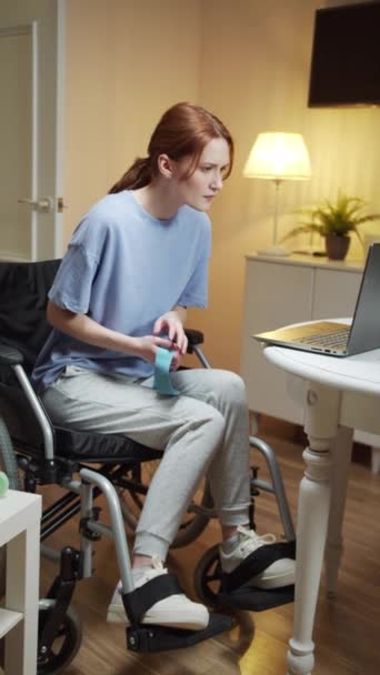 Een gehandicapte vrouw maakt handoefeningen met sport elastisch — Stockvideo