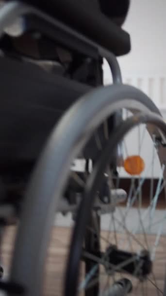 Un disabile è seduto sulla sua sedia a rotelle e guarda attraverso Internet — Video Stock