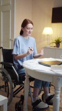 Engelli genç bir kadın biriyle konuşuyor ve diyagramlar gösteriyor. 