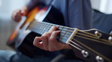 Genç engelli bir bayan gitar çalıyor ve şarkılar söylüyor.