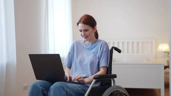 Женщина-инвалид сидит в инвалидном кресле и смотрит в интернет — стоковое фото