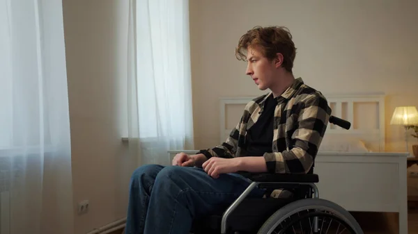 一个年轻的残疾人正坐在轮椅上绕着房间转 — 图库照片