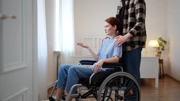 Чоловік водить свою дівчину в інвалідному візку — стокове фото