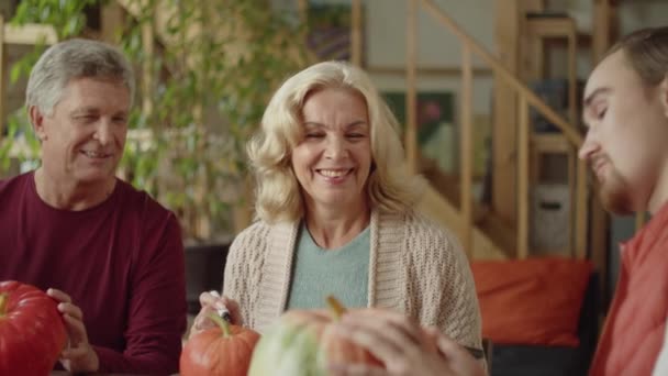 Babcia i staruszek rozmawiają o dyni z wnukiem na Halloween — Wideo stockowe