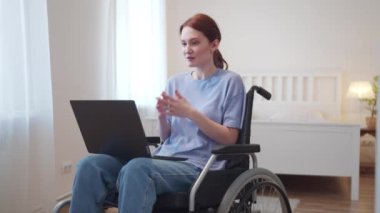 Engelli bir kadın tekerlekli sandalyesinde oturuyor ve arkadaşıyla konuşuyor.