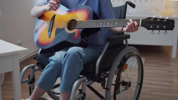 Mladá postižená dáma hraje na kytaru a zpívá písně — Stock video