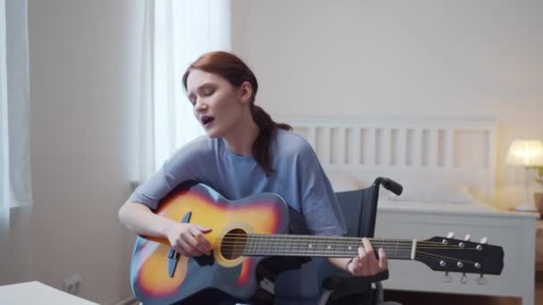 Eine behinderte Frau spielt Gitarre und singt Lieder — Stockvideo