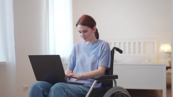 Una donna disabile è seduta sulla sedia a rotelle e guarda attraverso Internet — Video Stock