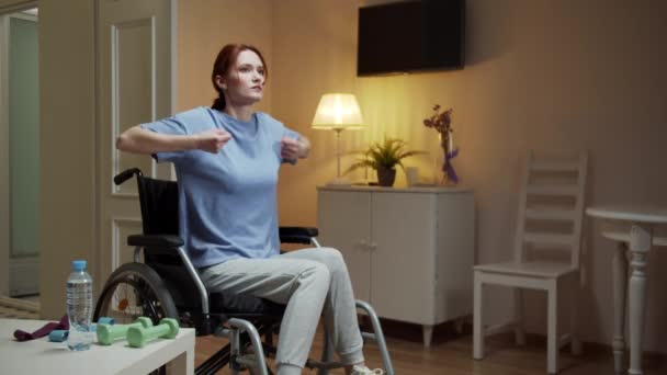 장애가 있는 한 여자가 초인종으로 손 운동을 하고 있다 — 비디오