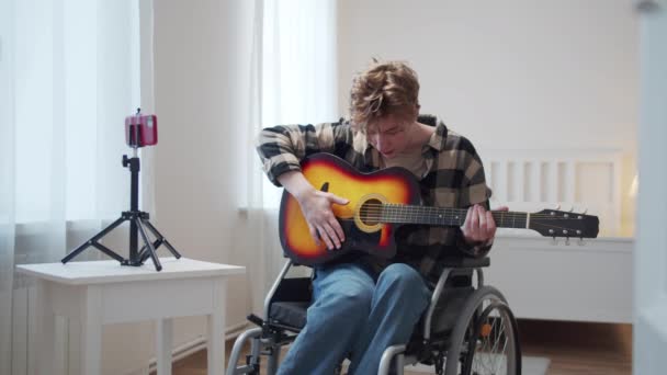 Člověk se zdravotním postižením učí, jak hrát na kytaru profesionálně — Stock video