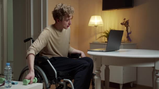 Een sportieve gehandicapte man maakt een oefening met halters — Stockvideo