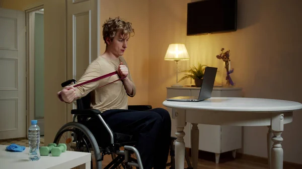 Un hombre discapacitado está haciendo ejercicios de mano con equipo especial — Foto de Stock