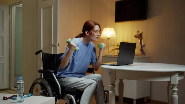 A disabled woman is making hand exercises with dumbbells — Stock Photo, Image