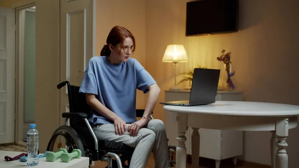 A young disabled woman is massaging her legs — Stock Photo, Image
