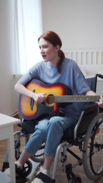 Eine junge behinderte Frau spielt Gitarre und singt Lieder — Stockvideo