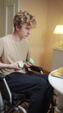 Engelli bir adam dambıllarla el kaldırıyor. 