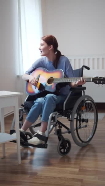 Een gehandicapte dame speelt gitaar en zingt liedjes — Stockvideo