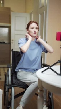 Engelli bir kadın videoda boyun egzersizi yapıyor. 