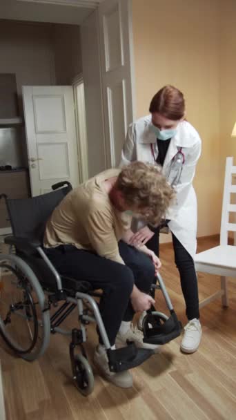 Sestra pomáhá pacientovi dostat tě z vozíku. — Stock video