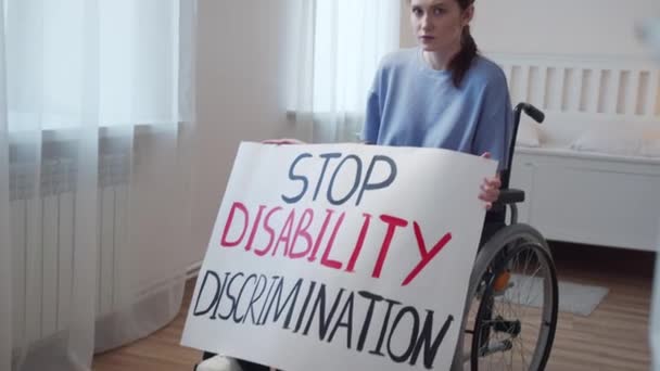 Engelli çekici bir kadın bir poster gösteriyor ve kameraya bakıyor. — Stok video