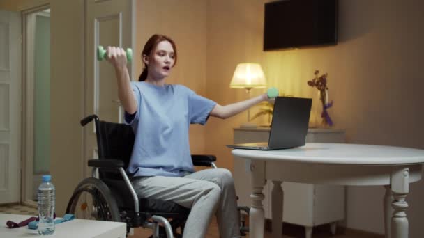 Een gehandicapte vrouw maakt handoefeningen met halters — Stockvideo