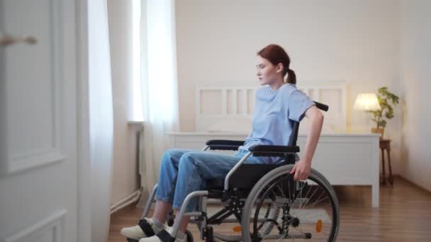 Mladá zdravotně postižená žena jezdí na invalidním vozíku po pokoji — Stock video