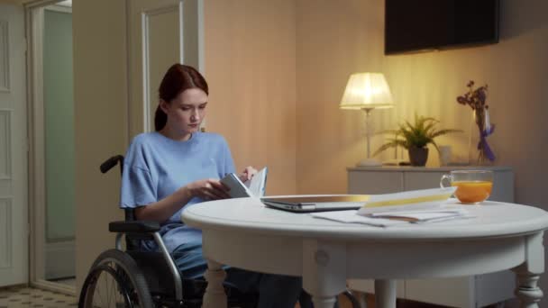 A young disabled woman is reading a book in silence — Stock Video