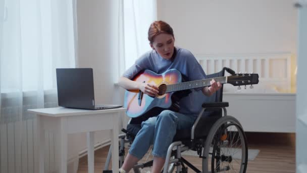 A disabled lady is learning to play the guitar on the Internet — Stock Video