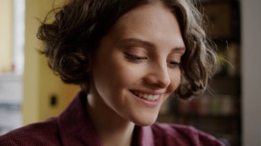 Yakışıklı bir kız bir şeye bakıyor ve gülümsüyor.