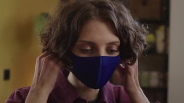 Genç bir kadın koruyucu bir maske takıyor.