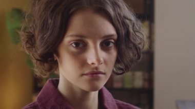 Genç ve güzel bir bayan kameraya bakıyor ve poz veriyor.