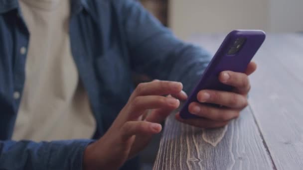 Un hombre guapo está mirando algo por teléfono y mirando a la cámara — Vídeos de Stock