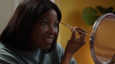 Güzel bir bayan cadılar bayramı makyajı çiziyor.