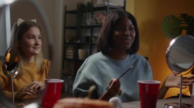 Kızlar Cadılar Bayramı makyajını tartışıyor.