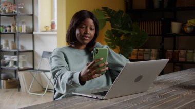 Yakışıklı bir kadın telefonuyla selfie çekiyor.