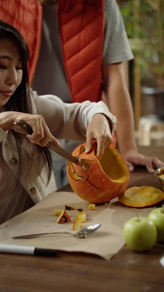 Una mujer atractiva está tallando la calabaza — Foto de Stock