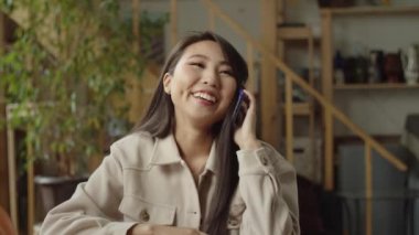  Güzel bir kadın telefonda konuşurken gülümsüyor.